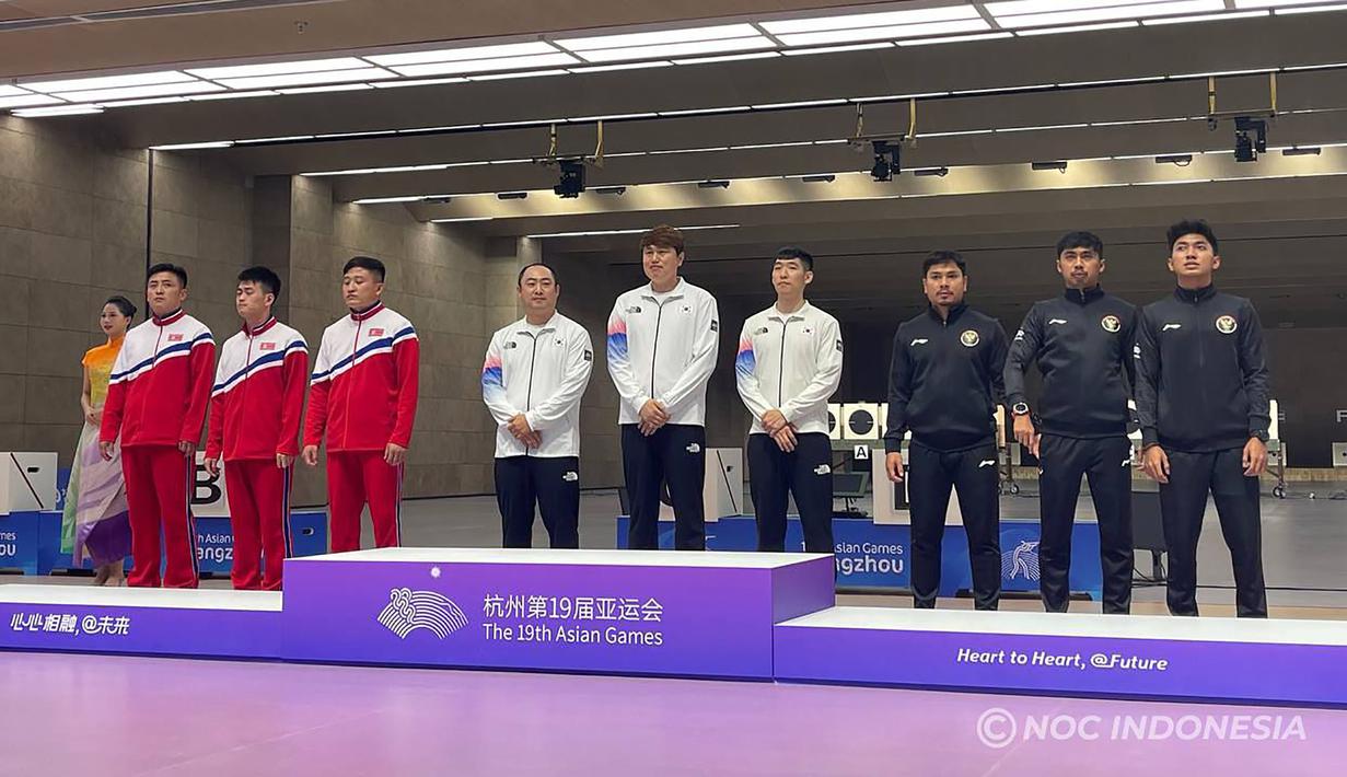 Tim menembak putra Indonesia (kanan) yang menempati peringkat ketiga dan berhak atas medali perunggu saat upacara penyerahan medali nomor 10 meter running target beregu putra cabang menembak Asian Games Hangzhou 2022 di Fuyang Yinhu Sports Centre, Hangzhou, China, Senin (25/9/2023). Medali emas diraih tim Korea Selatan (tengah) dan medali perak direbut tim Korea Utara (kiri). (NOC Indonesia)