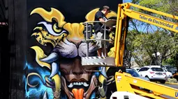 Seorang seniman membuat mural saat Festival Aliados di San Jose, Costa Rica (11/3). Mural sendiri adalah cara menggambar atau melukis di atas media dinding, tembok atau permukaan luas yang bersifat permanen lainnya. (AFP Photo/Ezequiel Becerra)