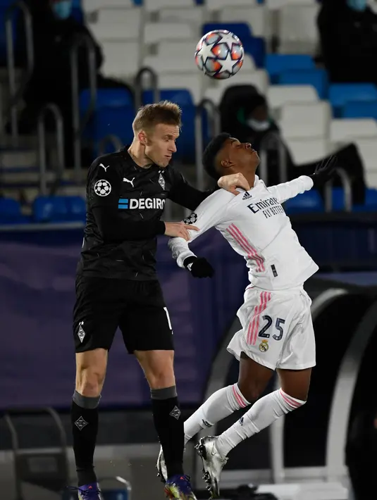 Bek Borussia Monchengladbach, Oscar Wendt berebut bola udara dengan penyerang Real Madrid, Rodrygo pada pertandingan Grup B Liga Champions di Estadio Alfredo Di Stefano, Kamis (10/12/2020). Madrid menang atas Monchengladbach 2-0. (AFP/PIERRE-PHILIPPE MARCOU)