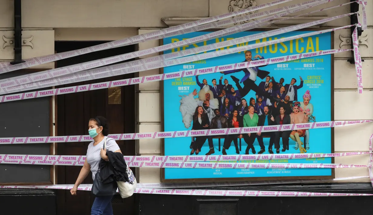Seorang wanita berjalan melewati Apollo Theater yang disegel, London, Inggris, Selasa (7/7/2020). Pemerintah Inggris akan menyalurkan paket bantuan sebesar 1,57 miliar poundsterling kepada industri seni, budaya, dan warisan untuk membantu mengatasi dampak pandemi COVID-19. (Xinhua/Tim Ireland)