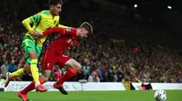 Bek Norwich City Dimitris Giannoulis (kiri) bersaing dengan bek Liverpool Conor Bradley pada babak ketiga Piala Liga Inggris di Carrow Road, Rabu (22/9/2021) dinihari WIB. Liverpool sukses menghajar Norwich City tiga gol tanpa balas di kandang lawan. (ADRIAN DENNIS / AFP)