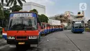 Bus Transjakarta melintasi armada Metromini 69 yang menunggu penumpang di Terminal Blok M, Jakarta, Rabu (13/11/2019). Hampir seluruh sopir Metromini saat ini tercekik mencari nafkah karena ekspansi Transjakarta, ojek online, dan ketatnya regulasi Dinas Perhubungan DKI. (merdeka.com/Iqbal Nugroho)