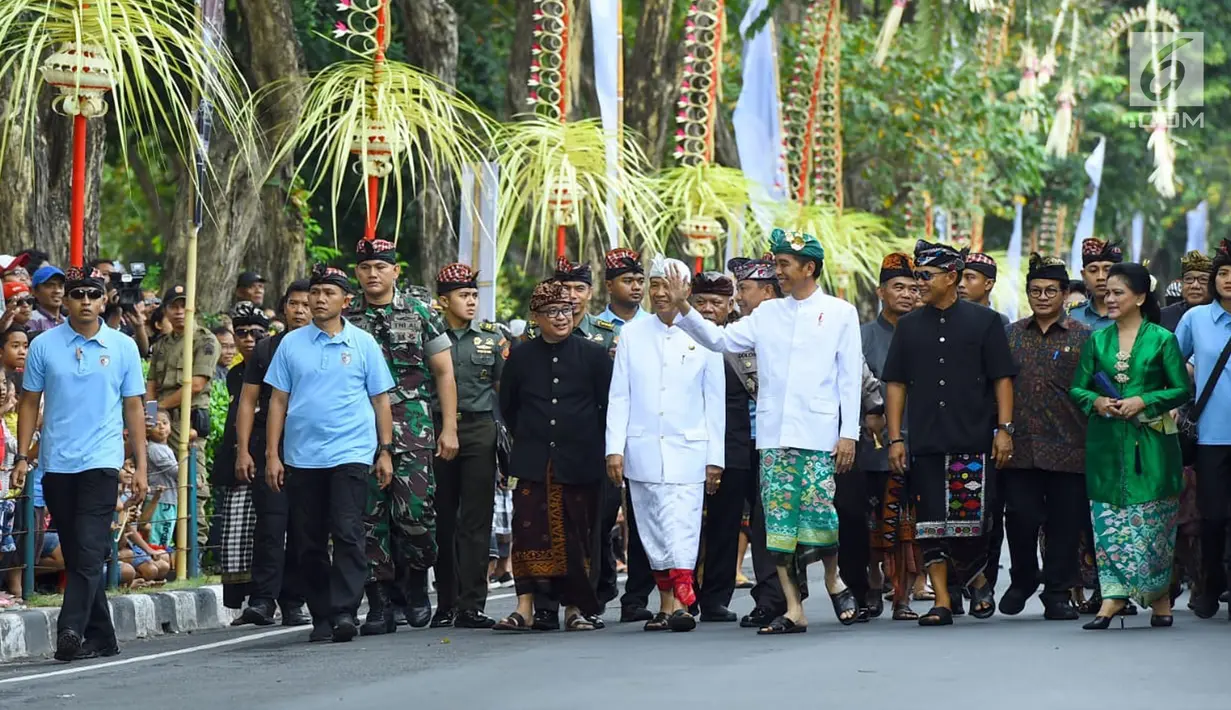 Presiden Joko Widodo menyapa warga saat mengikuti pawai pembukaan Pesta Kesenian Bali (PKB) ke-40 di Bali (23/6). Dalam acara tersebut, presiden tak hanya melepas peserta pawai, tapi juga turut menjadi peserta pawai. (Liputan6.com/Pool/Biro Pers Setpres)