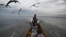 Pengunjung memberi makan burung camar di Danau Innlay yang terkenal di negara bagian Shan selatan, Myanmar, Sabtu (15/1/2022). Danau ini merupakan danau terbesar kedua di Myanmar dengan luas mencapai 116,3 kilometer persegi. (AP Photo)