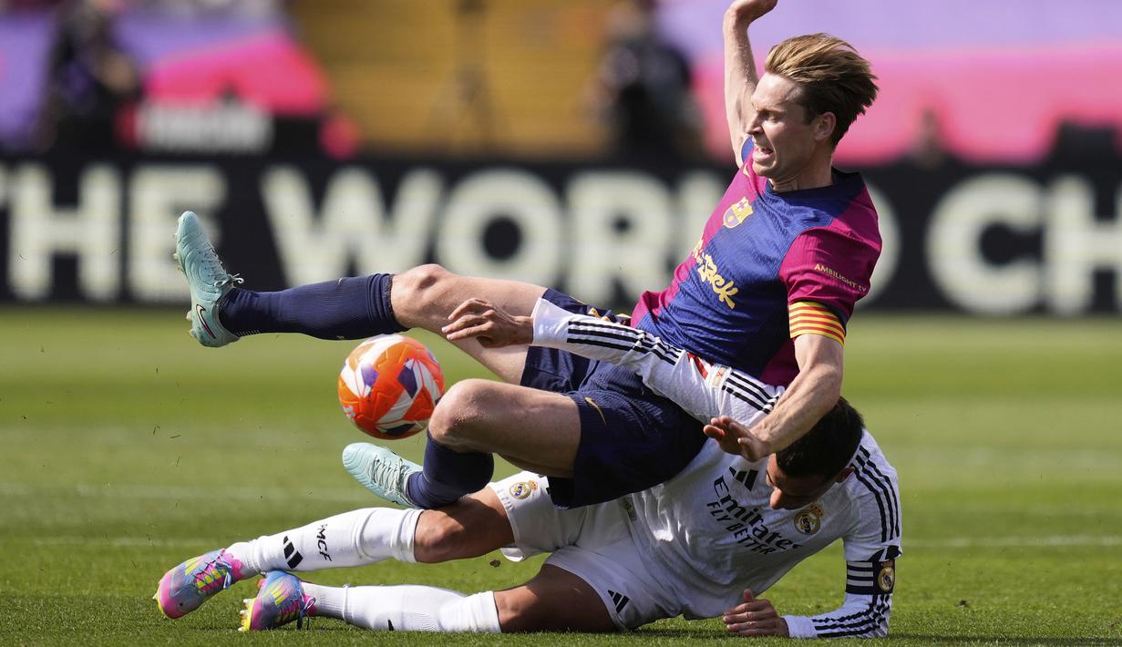 Pemain Barcelona, Frenkie De Jong (atas) berebut bola dengan pemain Real Madrid, Lucas Vazquez dalam laga lanjutan Liga Spanyol 2024/2025 di Estadi Olimpic Lluis Companys, Barcelona, Spanyol, Minggu (11/05/2025) waktu setempat. (AP Photo/Jose Breton)