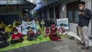 Siswa dan guru berdoa untuk 53 awak kapal selam KRI Nanggala 402 yang hilang hilang kontak, di sebuah sekolah Islam di Surabaya, Jumat (24/4/2021). Kapal selam KRI Nanggala-402 hilang kontak saat sedang melaksanakan latihan penembakan dengan torpedo di perairan utara Pulau Bali. (Juni Kriswanto/AFP)