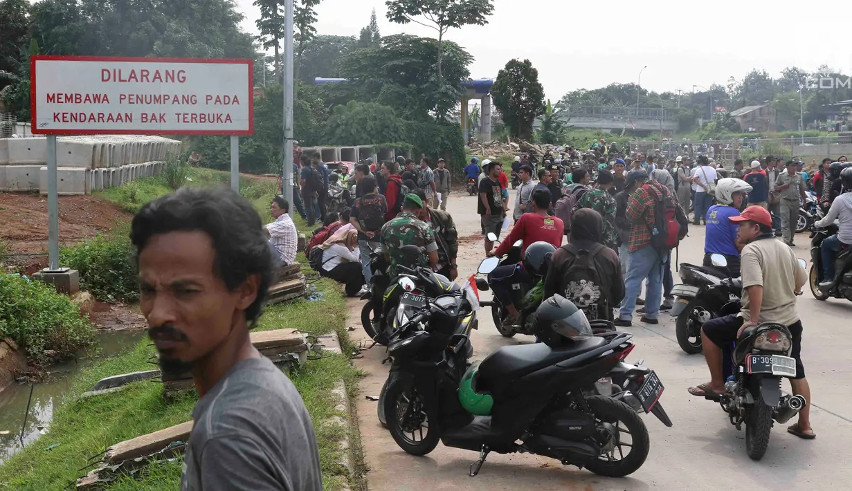 Warga berkerumun menyaksikan eksekusi bangunan rumah milik warga yang terdampak proyek Jalan Tol Cijago di kawasan Kukusan, Depok, Jawa Barat, Rabu (12/12). Di Kukusan, PN Depok kembali mengeksekusi 20 bidang lahan. (Liputan6.com/Immanuel Antonius)