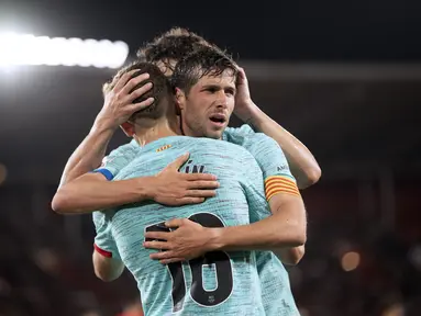 Gelandang Barcelona #16 Fermin Lopez diberi ucapan selamat oleh #20 Sergi Roberto setelah mencetak gol kedua timnya ke gawang Almeria pada laga jornada 36 La Liga 2023/2024 di Power Horse Stadium, Jumat (17/5/2024) dini hari WIB. (JORGE GUERRERO / AFP)