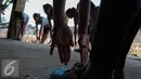 Sejumlah anak melakukan gerakan pemanasan saat berlatih balet di Bantaran Kali Ciliwung, Jakarta, Sabtu (29/8/2015). Pelatihan ini adalah kerjasama antara Kedubes Australia dengan Yayasan Bina Ballet Indonesia. (Liputan6.com/Faizal Fanani)