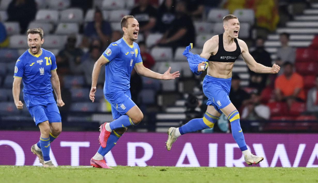 Pemain Timnas Ukraina, Artem Dovbyk, melakukan selebrasi dengan melepas jerseynya usai mencetak gol ke gawang Swedia pada babak 16 besar Euro 2020 di Stadion Hampden Park, Selasa (29/7/2021). (Stu Forster/Pool via AP)