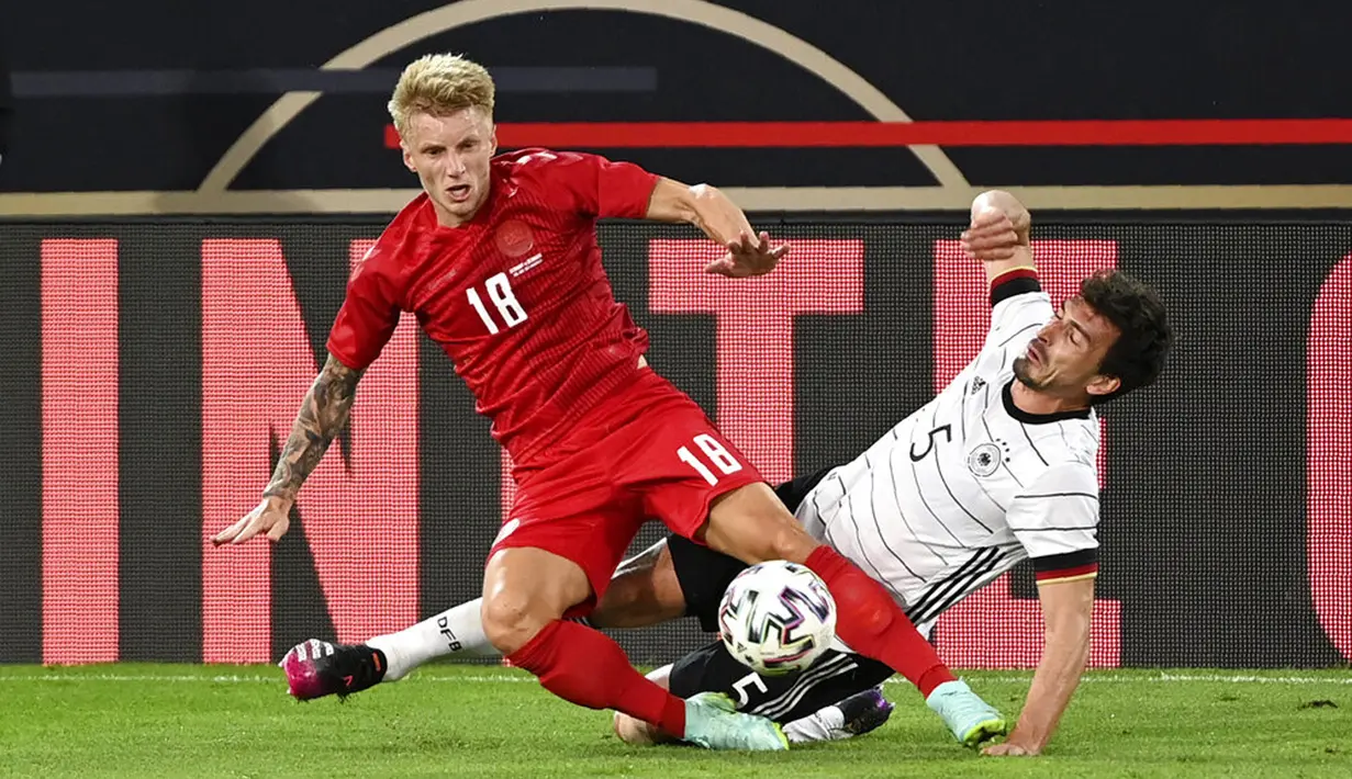 Pemain Jerman Mats Hummels (kanan) berebut bola dengan pemain Denmark Daniel Wass (kiri) pada pertandingan persahabatan di Tivoli Stadion Tirol, Innsbruck, Austria, Rabu (2/6/2021). Pertandingan berakhir dengan skor 1-1. (Frederico Gambarini/Pool via AP)