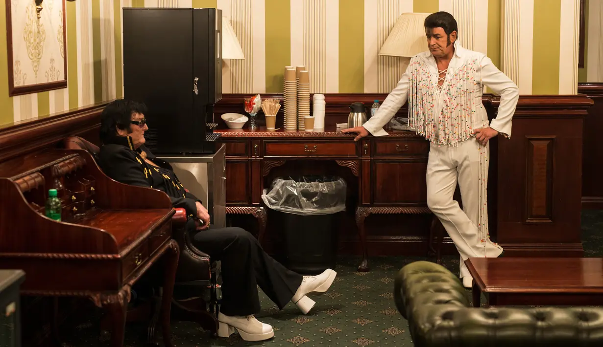 Artis Scott Chaple (kiri) dan Lee Aaron King berbincang di belakang panggung sebelum tampil dalam pembukaan 'Perayaan Elvis 2018' di Blackpool Winter Gardens, Barat Laut Inggris, Jumat (29/6). Festival digelar selama tiga hari. (Oli SCARFF/AFP)