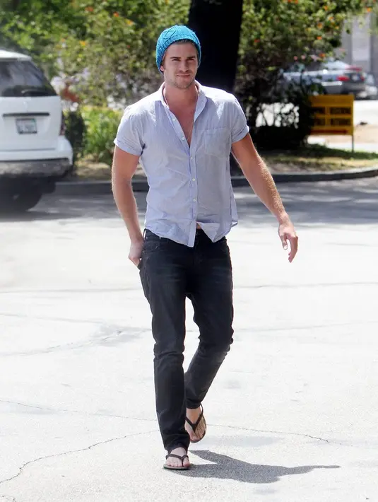 Liam Hemsworth terlihat cuek dan santai banget memakai sandal jepit. (POPSUGAR)
