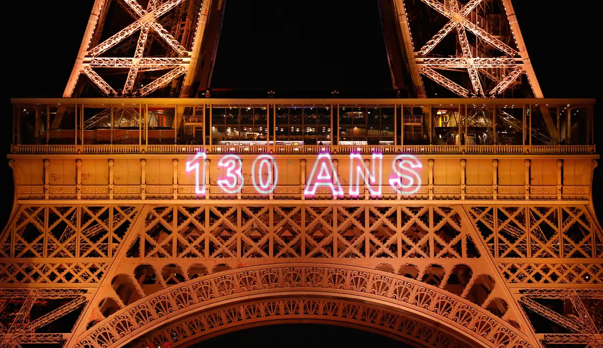 Menara Eiffel diterangi selama pertunjukan cahaya untuk perayaan ulang tahunnya ke-130 tahun di Paris, Rabu (15/5/2019). Paris memberikan ucapan ulang tahun kepada Menara Eiffel dengan pertunjukan laser yang rumit menelusuri kembali sejarah 130 tahun monumen itu. (AP/Christophe Ena)