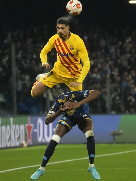 Bek Barcelona Ronald Araujo berebut bola dengan penyerang Napoli Victor Osimhen pada play-off fase gugur Liga Europa 2021/2022 di Stadion Diego Armando Maradona, Jumat (25/2/2022) dini hari WIB. Barcelona melaju ke babak 16 besar usai menang telak 4-2 di kandang Napoli. (AP Photo/Gregorio Borgia)