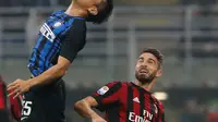 Pemain Inter Milan, Yuto Nagatomo menyundul bola di depan pemain AC Milan, Fabio Borini pada pekan kedelapan Liga Italia di Stadion Giuseppe Meazza, Minggu (15/10). Gol Inter Milan diborong oleh Mauro Icardi, 3-2. (AP/Antonio Calanni)