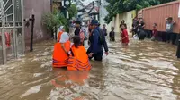 Petugas DPKP Kota Depok membantu mengarahkan siswa terjebak banjir usai pulang sekolah di wilayah Pancoran Mas, Depok. (Istimewa)