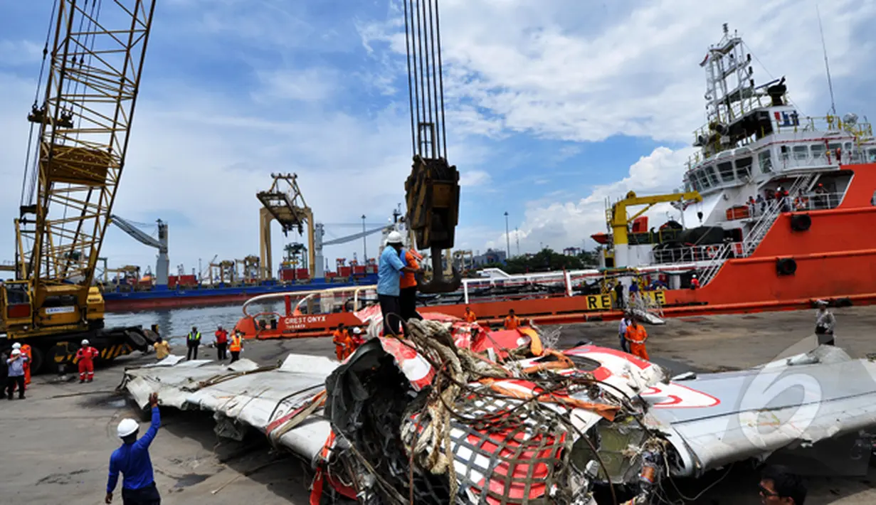 Petugas Basarnas sedang melepaskan kait yang mengangkat bangkai badan pesawat Airasia QZ8501, Pelabuhan Tanjung Priok, Jakarta, Senin (2/3/2015).  (Liputan6.com/Faizal Fanani)