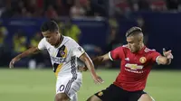 Pemain LA Galaxy, Giovani dos Santos (kiri) berusaha melewati adangan pemain Manchester United, Andreas Pereira pada laga persahabatan di StubHub Center, California, Sabtu (15/7/2017). MU menang 5-2. (AP/Jae C. Hong)