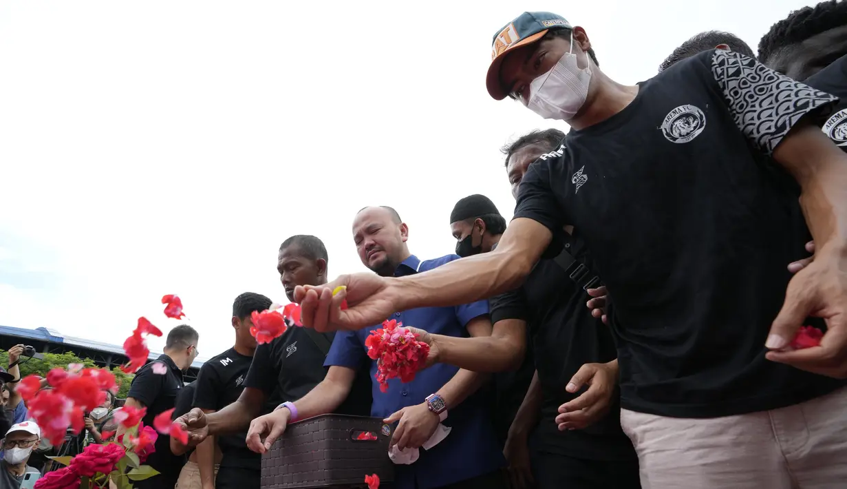 Pemain dan ofisial klub Arema FC menaburkan bunga untuk para korban kerusuhan Stadion Kanjuruhan Malang di Malang, Senin, 3 Oktober 2022. Tragedi Kanjuruhan itu pecah usai laga Arema FC menjamu Persebaya Surabaya yang berakhir dengan skor 2-3 untuk kemenangan tim tamu. (AP Photo/Achmad Ibrahim)