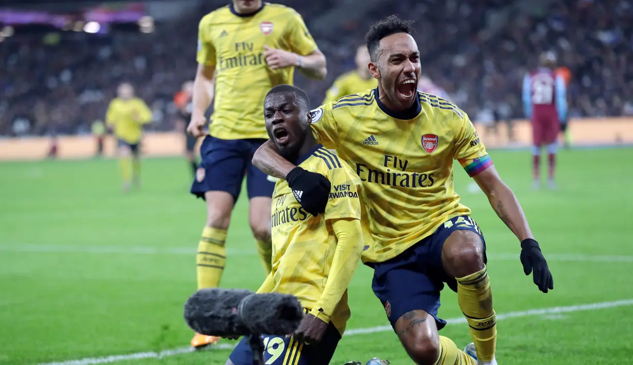 Pemain Arsenal Nicolas Pepe (kiri) merayakan golnya ke gawang West Ham United bersama Pierre-Emerick Aubameyang pada pertandingan Liga Inggris di London Stadium, London, Inggris, Senin (9/12/2019). Arsenal menang 3-1. (AP Photo/Kirsty Wigglesworth)