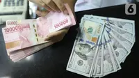 Teller menghitung mata uang rupiah dan dolar AS di Jakarta, Selasa (15/10/219). Hari ini rupiah ditutup melemah terhadap dolar AS. (Liputan6.com/Angga Yuniar)