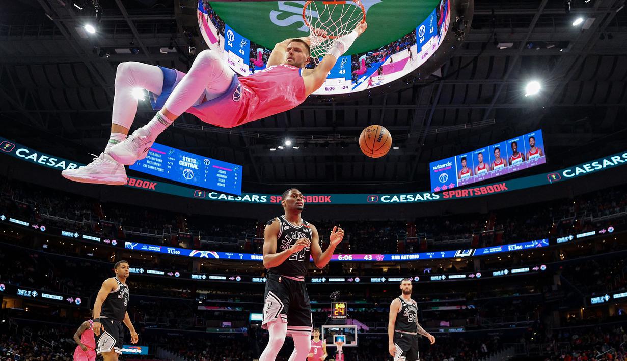Pemain Washinton Wizards, Kristaps Porzingis mencetak poin saat melawan San Antonio Spurs pada laga NBA 2023 di Capital One Arena, Washington, 24 Maret 2023 in Washington. (AFP/Getty Images/Patrick Smith)