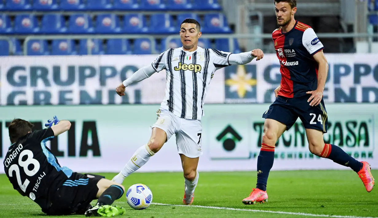 Striker Juventus, Cristiano Ronaldo, berusaha melewati kiper Cagliari, Alessio Cragno, pada laga Liga Italia di Sardegna Arena, Minggu (14/3/2021). Juventus menang dengan skor 3-1. (AFP/Albert0 Pizzoli)