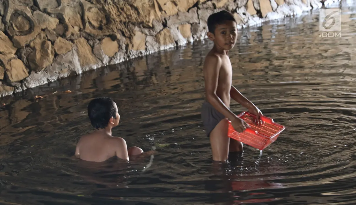 Anak-anak bermain sambil mencari ikan di Kali Pancoran, Jakarta, Jumat (14/9). Meski air kali yang keruh dan kotor dapat menyebabkan gangguan kesehatan, tidak menyurutkan niat anak-anak tersebut untuk tetap bermain. (Liputan6.com/Immanuel Antonius)