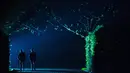 Pengunjug berada di dekat seni instalasi cahaya "Painting the Night" karya seniman Austria Victoria Coeln saat hujan turun di taman Heruerhae Gaerten di Hanover, Jerman utara, (4/5). (AFP Photo/dpa/Silas Stein/Jerman Out)