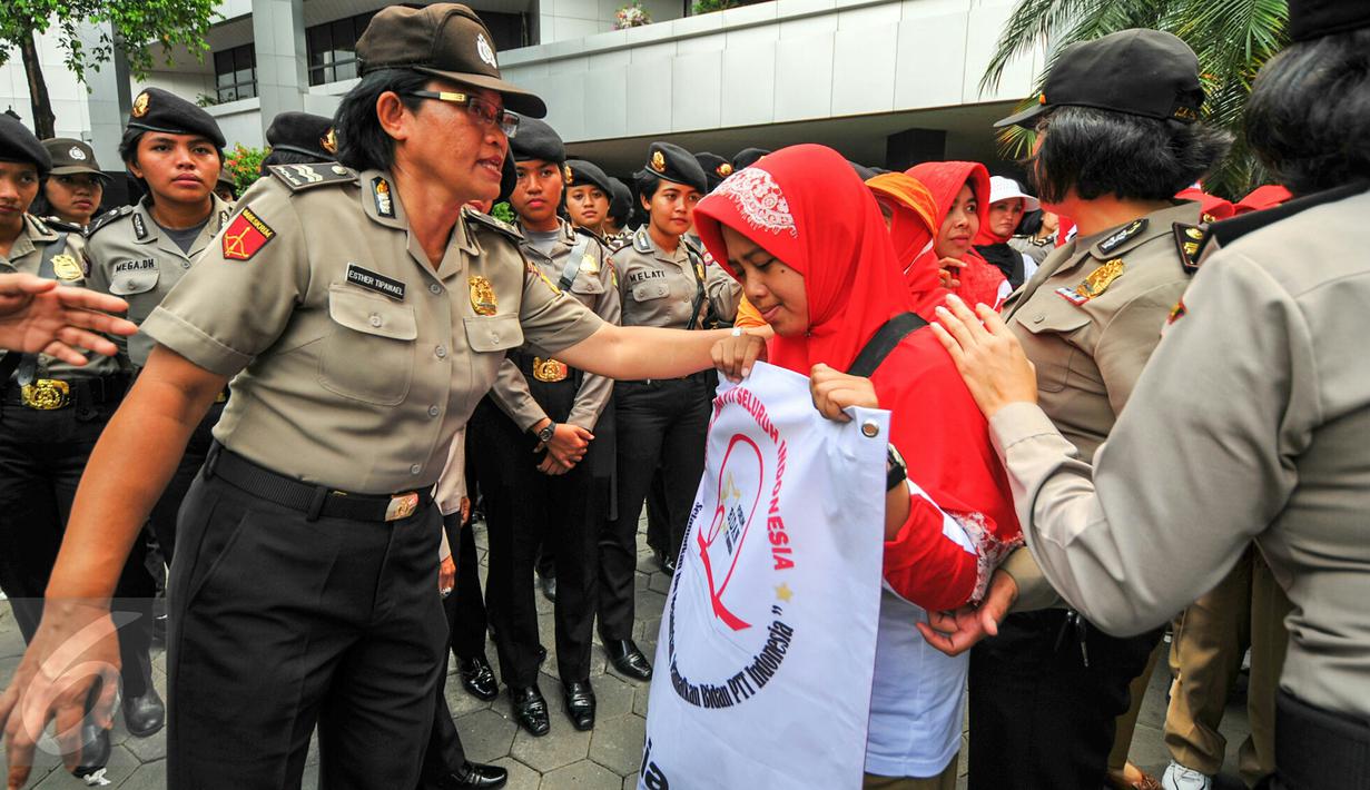 Seorang polwan berdialog dengan pendemo agar tidak menutup akses jalan ketika menggelar demonstrasi di depan gedung Kemenkes, Jakarta, Rabu (4/5). Para bidan desa berdemo menuntut diangkat menjadi pegawai tetap tanpa syarat.  (Liputan6.com/Yoppy Renato)