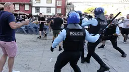 Polisi membubarkan suporter Manchester City yang berkelahi saat minum di tepi sungai Douro di Porto, Portugal (28/5/2021).  Para suporter melanggar jam malam dengan menghabiskan waktu di pub dan bar. (AP Photo/Luis Vieira)