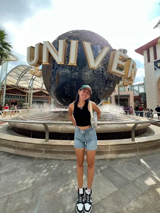 Potret liburan ala Shenina Cinnamon di Singapura. Ia tampil modis mengenakan crop top hitam dan short pants jeans. [Foto: Instagram/shenacinnamon]