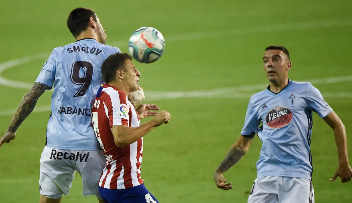 Bek Atletico Madrid, Santiago Arias, berebut bola dengan penyerang Celta Vigo, Smolov, pada laga lanjutan La Liga di Abanca-Balaidos, Rabu (8/7/2020) dini hari WIB. Atletico Madrid ditahan imbang 1-1 oleh Celta Vigo. (AFP/Miguel Riopa)