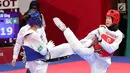 Atlet taekwondo putri Indonesia, Fitriyana Yusuf berhadapan dengan Liu Qing dari Makau pada babak 16 besar di Jakarta Convention Center (JCC), Senin (20/8). Fitriyana kalah tipis 21 - 25 pada kelas Wanita 67 kg. (Liputan6.com/Fery Pradolo)