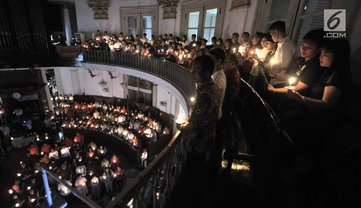 Jemaat memanjatkan doa dengan menyalakan lilin pada Misa Malam Natal di Gereja Immanuel, Jakarta, Senin (24/12). Misa Natal tahun ini mengangkat tema Membangun Spiritualitas Damai yang Menciptakan Perdamaian. (Merdeka.com/Iqbal S. Nugroho)