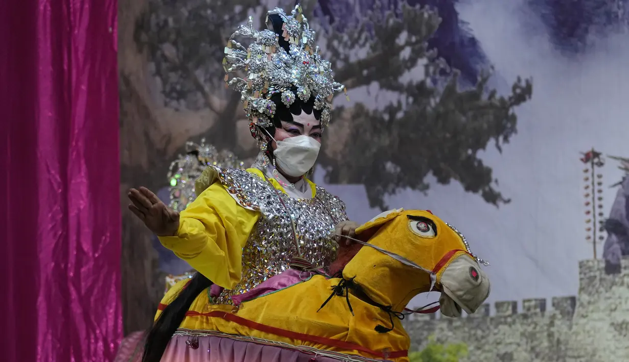 Seorang pemain opera memakai masker saat tampil di atas panggung di Bangkok, Rabu (6/10/2021). Sempat vakum, pertunjukan opera Tiongkok di Thailand kembali dihidupkan meski belakangan ini kasus harian Covid-19 kembali meningkat. (AP Photo/Sakchai Lalit)