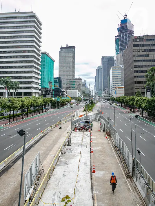 Aktivitas pekerja saat menggarap proyek MRT Fase II Bundaran HI-Harmoni di Jalan M.H. Thamrin, Jakarta, Rabu (10/2/2021). PT MRT Jakarta mengungkapkan pembangunan jalur MRT Jakarta Fase II Bundaran HI-Harmoni molor akibat pandemi COVID-19. (Liputan6.com/Faizal Fanani)