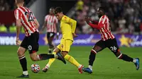 Gelandang Liverpool asal Brasil Roberto Firmino (tengah) melakukan umpan silang dibayangi pemain Brentford pada matchday keenam Liga Inggris di Brentford Community Stadium, Sabtu (25/9/2021). Liverpool ditahan imbang 3-3 oleh tuan rumah Brentford. (Glyn KIRK / AFP)