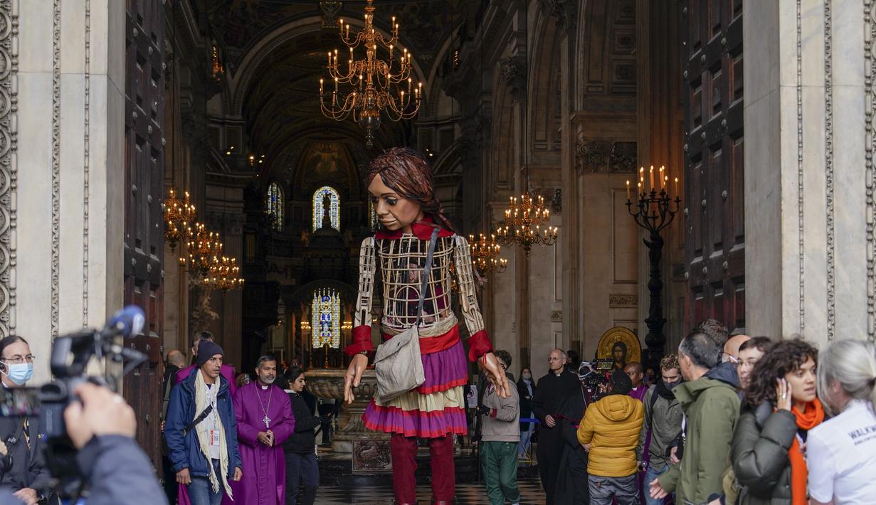 Boneka raksasa Little Amal tiba di Katedral St Paul, di London, Inggris, Sabtu (23/10/2021). Kedatangan Little Amal di kota London, Inggris, disambut ratusan warga pada Sabtu (23/10) waktu setempat. (AP Photo/Alberto Pezzali)