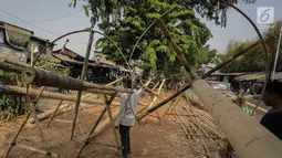 Pedagang membersihkan batang pinang yang akan dijual di kawasan Manggarai, Jakarta, Selasa (6/8/2019). Menjelang HUT RI ke-74 , penjual batang pinang musiman memasarkan dagangannya yang biasa digunakan untuk perlombaan panjat pinang. (Liputan6.com/Faizal Fanani)