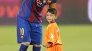 Bintang Barcelona Lionel Messi dan bocah Afghanistan, Murtaza Ahmadi berbincang jelang laga melawan Al Ahli di Doha, Qatar, Selasa (13/12). Murtaza menjadi sensasi di internet karena mengenakan plastik bernomor punggung 10 untuk Messi. (Karim Jaafar/AFP)