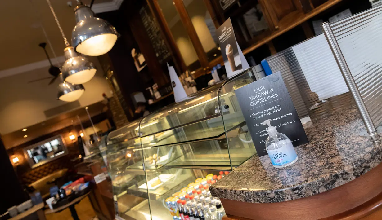 Cairan pembersih tangan  diletakkan di meja di Caffe Nero yang dibuka kembali untuk layanan dibawa pulang di Maida Vale di London (10/6/2020). Beberapa kedai kopi di Inggris telah dibuka kembali untuk pengiriman atau layanan takeaway dengan mengikuti aturan jaga jarak sosial. (Xinhua/Han Yan)