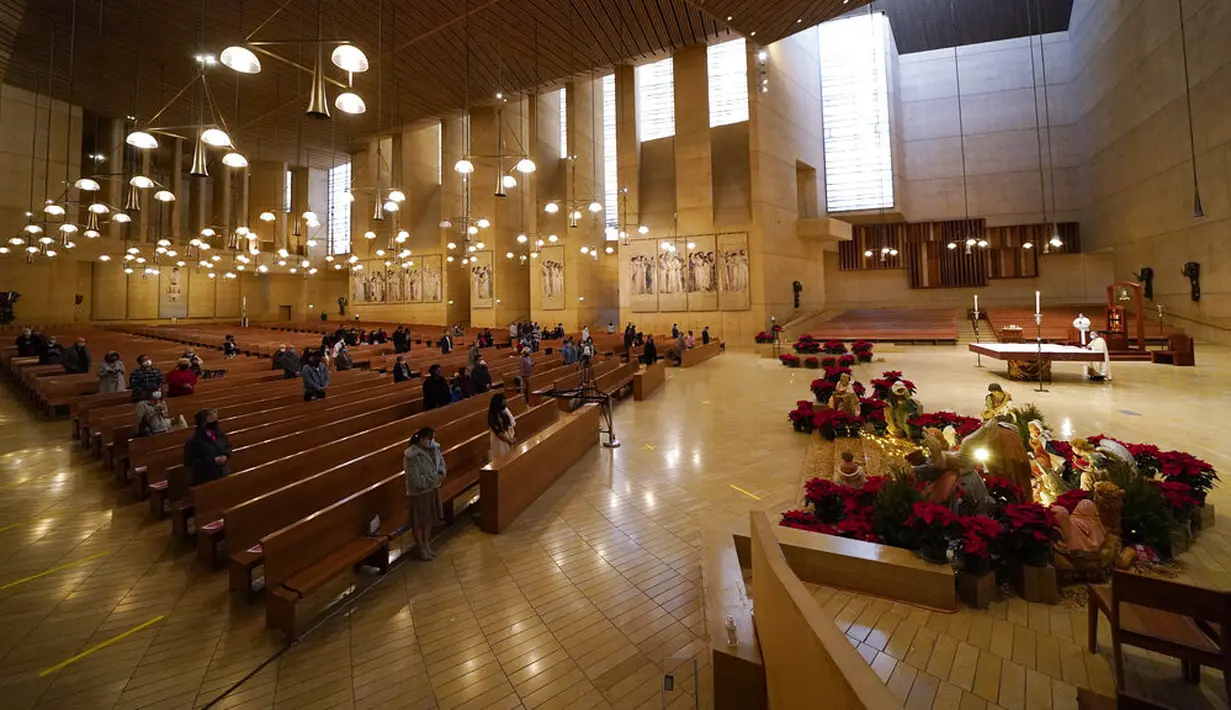 Para jemaat berkumpul untuk misa pada malam Natal di Katedral Our Lady of the Angels, Los Angeles, Amerika Serikat,  Kamis (24/12/2020). Natal tahun ini dirayakan oleh umat Kristiani dunia di tengah pandemi COVID-19. (AP Photo/Ashley Landis)