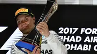 Valtteri Bottas mengangkat trofi juara seetalah finis pertama pada balapan F1 Abu Dhabi di Yas Marina circuit , (26/11/2017). (AFP/Giuseppe Cacace)