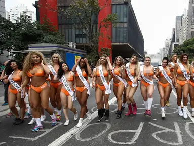 Sejumlah wanita seksi menyusuri jalanan di Sao Paulo, Senin (8/8). Mengenakan bikini, para wanita tersebut mempromosikan kontes Miss BumBum 2016 yaitu kontes yang menganugerahi wanita dengan pantat terindah seantero Brasil. (Miguel SCHINCARIOL/AFP)