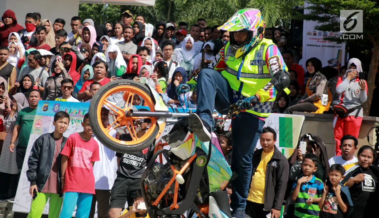Aksi freestyle motor saat menghibur warga selama kegiatan Millenial Road Safety Festival Gorontalo, Minggu (10/2). Atraksi freestyle tesebut untuk memeriahkan acara Millenial Road Safety Festival . (Liputan6.com/Rahmad Arfandi Ibrahim)