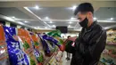 Seorang pria melihat paket makanan ringan merek Taeha yang diproduksi oleh Pabrik Bahan Makanan Unha Taesong di sebuah toko di Pyongyang, Korea Utara, 6 April 2021. (KIM Won Jin/AFP)