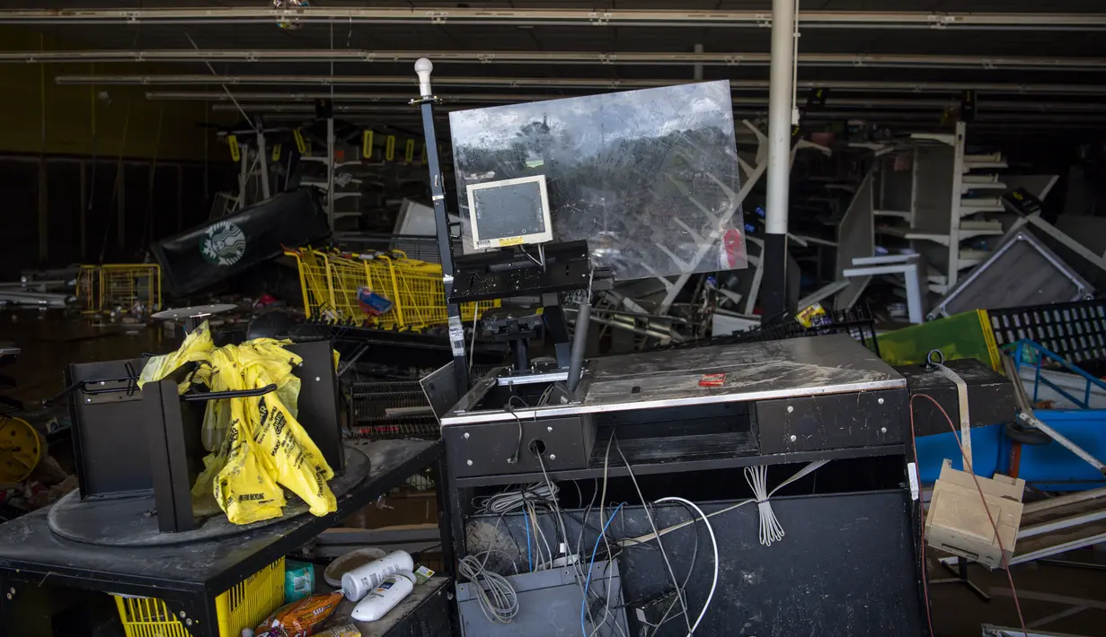 Bagian dalam Dollar General di Waverly, Tennessee, terlihat berantakan setelah banjir besar akibat hujan yang memecahkan rekor, Minggu (22/8/2021). Air banjir telah hilang, namun meninggalkan mobil-mobil yang rusak dan sisa-sisa kehancuran dari bisnis dan rumah. (Josie Norris/The Tennessean via AP)