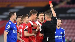 Bek Southampton, Jannik Vestergaard (tengah) menerima kartu merah dari wasit Robert Jones saat melawan Leicester City dalam laga lanjutan Liga Inggris 2020/2021 pekan ke-34 di St Mary's Stadium, Southampton, Jumat (30/4/2021). Southampton bermain imbang 1-1 dengan Leicester. (AFP/Neil Hall/Pool)